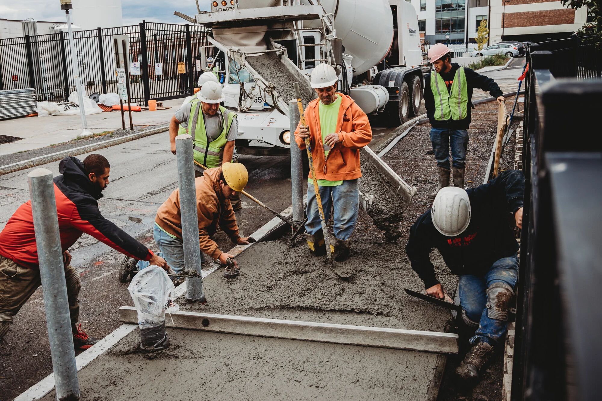 Crew placing and screeding concrete on a federal campus walkway
