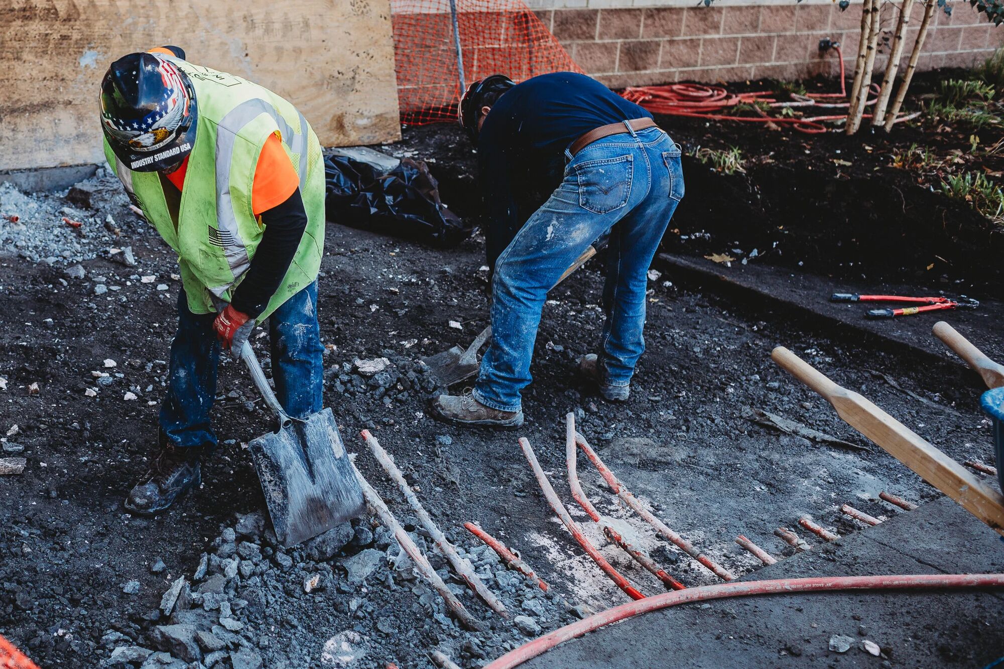 Two Industry Standard USA crew members walking an active worksite
