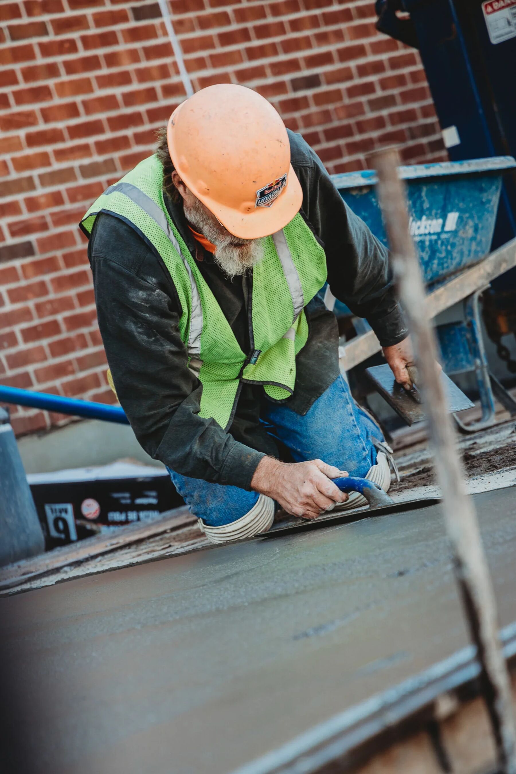 A crew member finishing concrete on a campus walkway