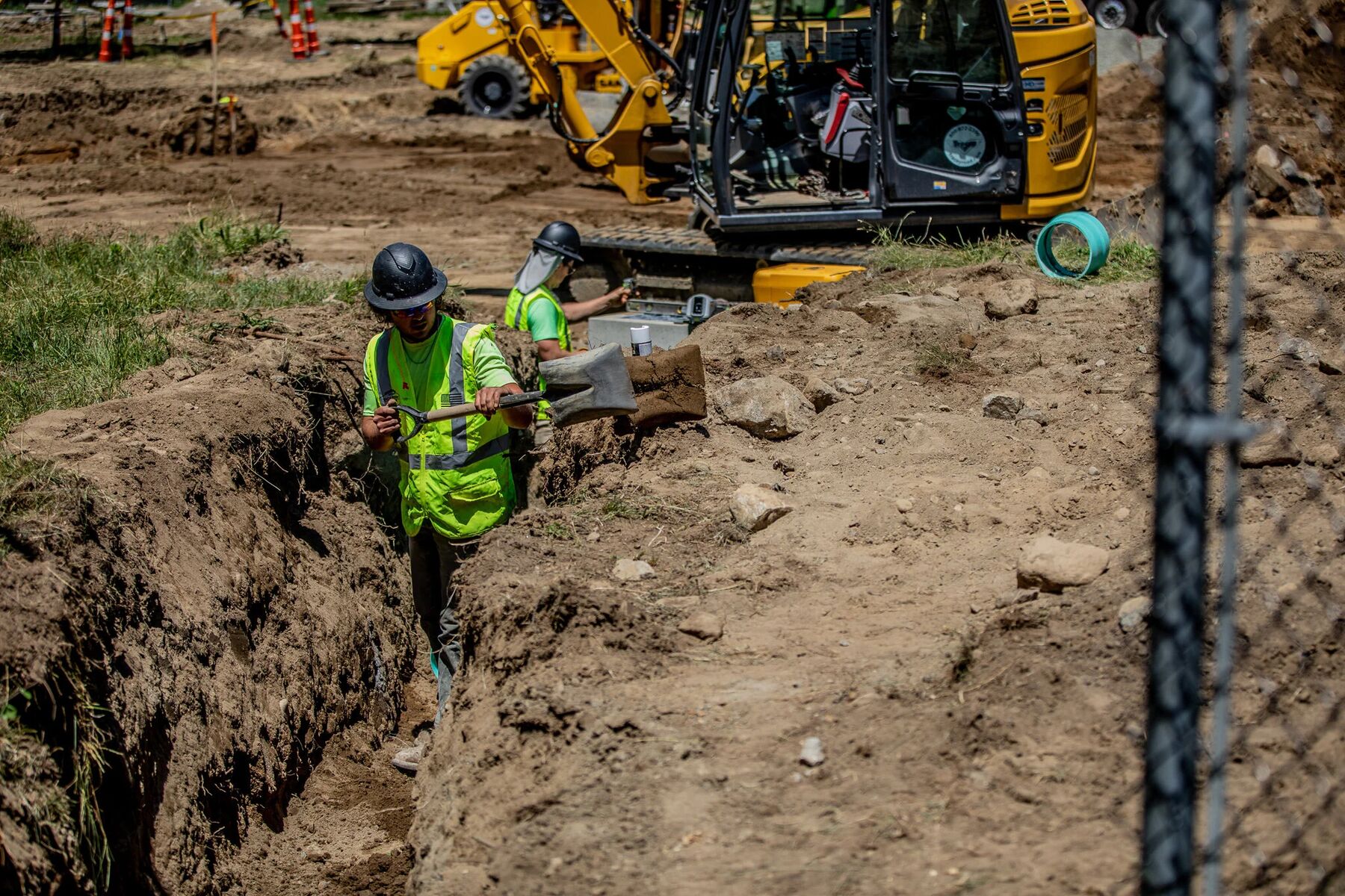 Crew setting underground pipe in an open trench at the Montrose VA campus
